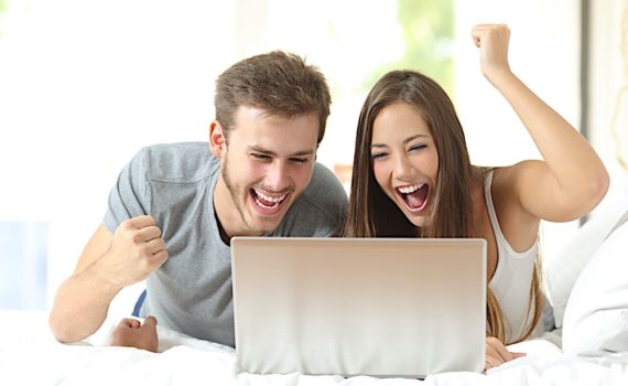 Euphoric marriage winning with a laptop at home