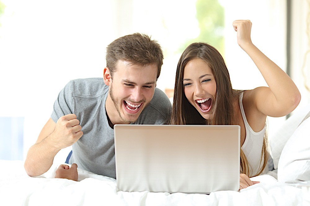 Euphoric marriage winning with a laptop at home